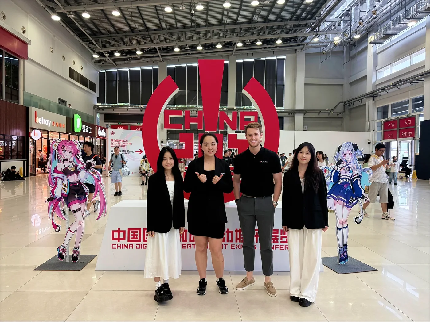 Four members of the Aurora team smiling together at an exhibition