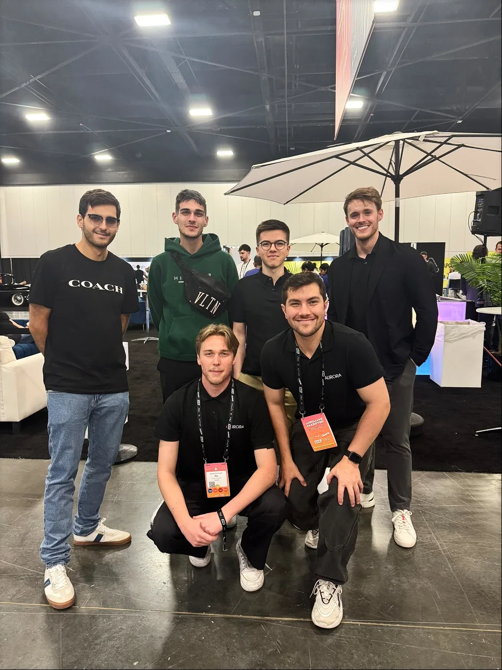 Six people, several in Aurora shirts, posing together at an industry event